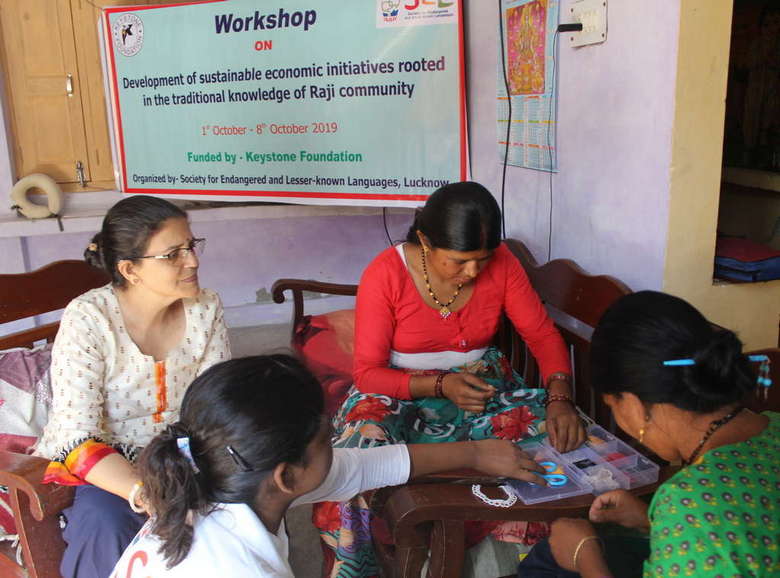 Participants of the workshop engrossed in making their traditional jewelry as Dr. Rastogi looks on